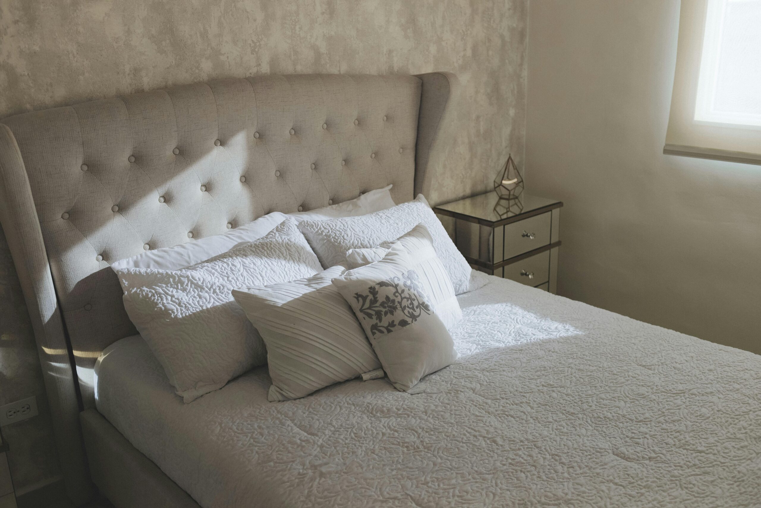 A serene bedroom featuring plush bedding and soft lighting for a cozy atmosphere.