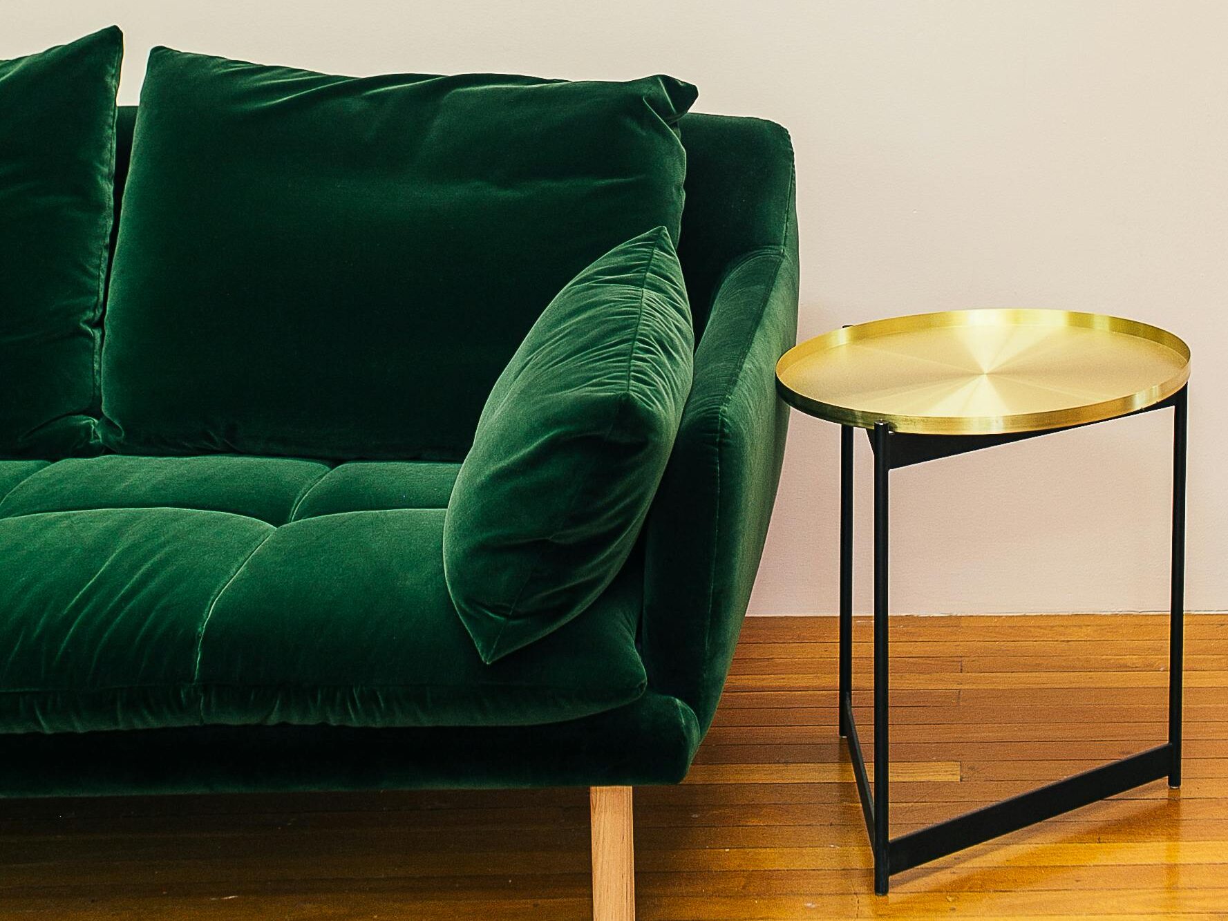 Elegant living room setup featuring a plush green sofa and a chic gold side table.