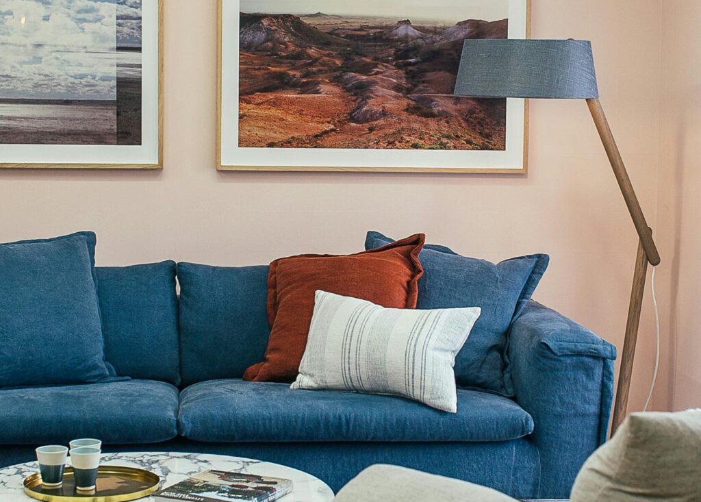 drain-cleaning Contemporary living room with blue sofa, artwork, and decor for a cozy ambiance.
